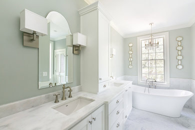 Example of a mid-sized transitional master white tile and marble tile marble floor and white floor bathroom design in Charleston with shaker cabinets, white cabinets, a one-piece toilet, gray walls, an undermount sink, marble countertops and a hinged shower door
