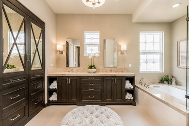 Large elegant master multicolored tile and porcelain tile porcelain tile and beige floor corner shower photo in Orange County with recessed-panel cabinets, dark wood cabinets, an undermount tub, a one-piece toilet, beige walls, an undermount sink, marble countertops, a hinged shower door and beige countertops