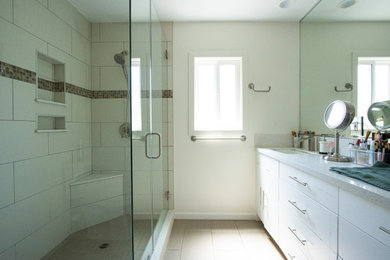 Large minimalist master porcelain tile, beige floor and double-sink bathroom photo in Los Angeles with white cabinets, white walls, a drop-in sink, marble countertops, a hinged shower door, white countertops and a built-in vanity