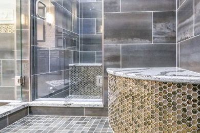 This is an example of an expansive classic ensuite bathroom in Cleveland with raised-panel cabinets, grey cabinets, a claw-foot bath, a walk-in shower, a two-piece toilet, multi-coloured tiles, porcelain tiles, beige walls, porcelain flooring, a vessel sink, engineered stone worktops, grey floors, a hinged door and grey worktops.