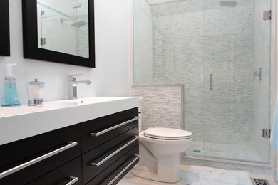 Design ideas for a large contemporary ensuite bathroom in Toronto with flat-panel cabinets, black cabinets, an alcove shower, a one-piece toilet, stone tiles, white walls, marble flooring, an integrated sink and quartz worktops.