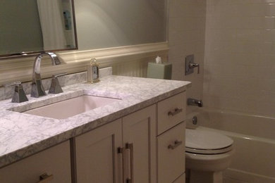 Réalisation d'une salle de bain design avec un lavabo encastré et un plan de toilette en marbre.
