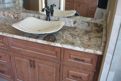 Imagen de cuarto de baño clásico con lavabo encastrado, armarios estilo shaker, puertas de armario de madera clara y encimera de granito