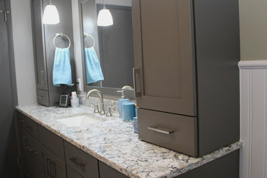 Imagen de cuarto de baño principal clásico renovado de tamaño medio con lavabo bajoencimera, armarios con paneles empotrados, puertas de armario grises, encimera de cuarzo compacto y paredes grises