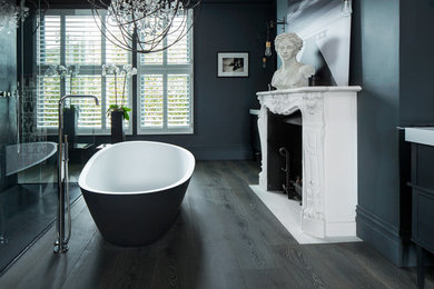 Klassisches Badezimmer mit freistehender Badewanne, blauer Wandfarbe und dunklem Holzboden in London