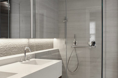 Example of a mid-sized trendy master beige tile and ceramic tile ceramic tile and beige floor bathroom design in New York with glass-front cabinets, dark wood cabinets, a one-piece toilet, beige walls, an integrated sink, quartz countertops, a hinged shower door and beige countertops