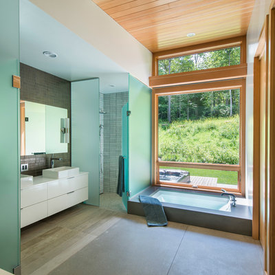Inspiration for a mid-sized contemporary master gray tile and ceramic tile concrete floor bathroom remodel in Burlington with white cabinets, white walls, flat-panel cabinets, a one-piece toilet, a vessel sink and quartz countertops