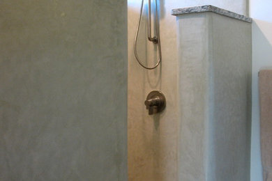 На фото: ванная комната с душем без бортиков, плиткой из известняка и бетонным полом с