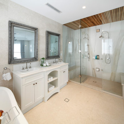 Example of a classic master beige tile and marble tile marble floor and beige floor freestanding bathtub design in Sydney with recessed-panel cabinets, white cabinets, quartz countertops and white countertops