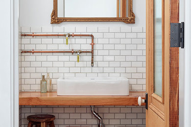Example of a mid-sized classic 3/4 white tile and ceramic tile bathroom design in New York with a vessel sink, medium tone wood cabinets and white walls