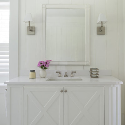 Inspiration for a large coastal linoleum floor and white floor bathroom remodel in San Francisco with white cabinets, white walls, white countertops, furniture-like cabinets and an undermount sink