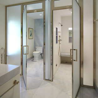 Huge transitional master white tile and stone slab marble floor and gray floor bathroom photo in New York with flat-panel cabinets, white cabinets, white walls, marble countertops, a two-piece toilet and a hinged shower door