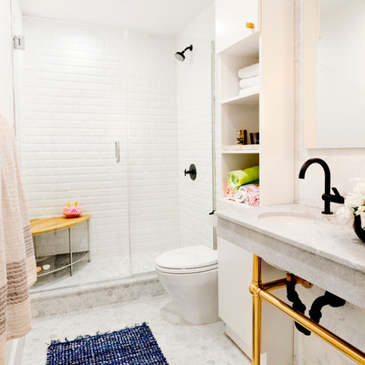 Example of a mid-sized transitional 3/4 white tile and subway tile mosaic tile floor alcove shower design in New York with open cabinets, white cabinets, white walls, an undermount sink, a one-piece toilet, marble countertops, a hinged shower door and gray countertops