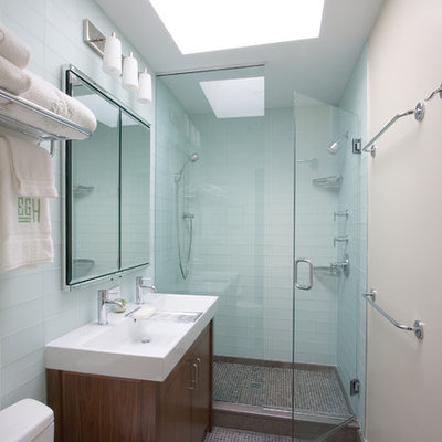 Inspiration for a contemporary blue tile and glass tile double shower remodel in New York with a trough sink, dark wood cabinets, a two-piece toilet and flat-panel cabinets