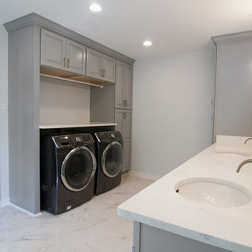 Grey and white master bathroom with laundry area.