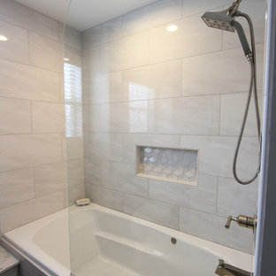 Inspiration för små klassiska en-suite badrum, med luckor med upphöjd panel, grå skåp, ett badkar i en alkov, en dusch i en alkov, en toalettstol med separat cisternkåpa, grå kakel, porslinskakel, grå väggar, klinkergolv i porslin, ett undermonterad handfat, bänkskiva i akrylsten, grått golv och dusch med gångjärnsdörr