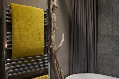 Aménagement d'une petite salle de bain contemporaine avec une baignoire indépendante, un carrelage gris, des carreaux de porcelaine, un mur gris, un sol en carrelage de porcelaine et un sol gris.