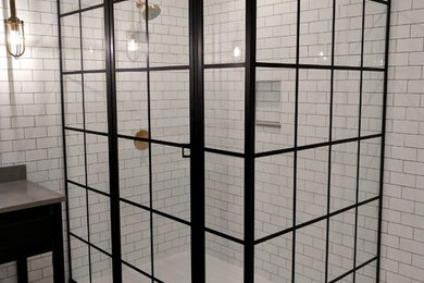 Corner shower - large modern subway tile corner shower idea in Minneapolis with a hinged shower door
