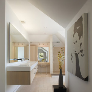 Inspiration for a small modern master beige tile and stone tile limestone floor bathroom remodel in Los Angeles with an undermount sink, flat-panel cabinets, light wood cabinets, solid surface countertops and white walls