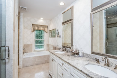 Huge elegant master beige tile bathroom photo in Detroit with raised-panel cabinets, white cabinets, white walls, an undermount sink and marble countertops