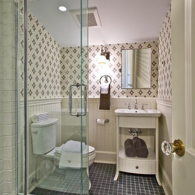 Corner shower - traditional black tile corner shower idea in New York with a wall-mount sink, furniture-like cabinets, white cabinets and a two-piece toilet