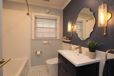 ヒューストンにある小さなトランジショナルスタイルのおしゃれな浴室 (フラットパネル扉のキャビネット、青いキャビネット、ドロップイン型浴槽、シャワー付き浴槽	、一体型トイレ	、白いタイル、磁器タイル、青い壁、セラミックタイルの床、一体型シンク、人工大理石カウンター、マルチカラーの床、シャワーカーテン、白い洗面カウンター) の写真