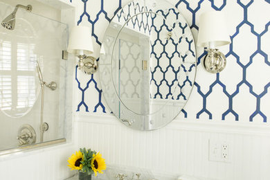 ニューヨークにある中くらいなトランジショナルスタイルのおしゃれなバスルーム (浴槽なし) (白いキャビネット、白い壁、アンダーカウンター洗面器、大理石の洗面台、落し込みパネル扉のキャビネット) の写真