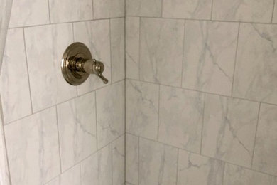 Modelo de cuarto de baño tradicional con ducha abierta, baldosas y/o azulejos grises, baldosas y/o azulejos de cerámica, paredes grises, suelo de baldosas de cerámica, lavabo bajoencimera, suelo gris, ducha abierta y encimeras blancas