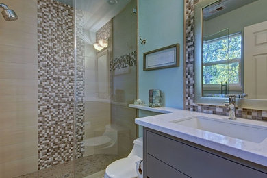 Inspiration for a small contemporary shower room bathroom in Sacramento with flat-panel cabinets, granite worktops, a one-piece toilet, beige tiles, mosaic tiles, an alcove shower, a submerged sink and a hinged door.