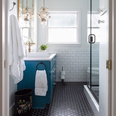 Elegant 3/4 white tile and subway tile black floor corner shower photo in Austin with flat-panel cabinets, blue cabinets, white walls, a vessel sink and a hinged shower door
