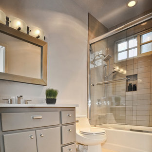 Ispirazione per una piccola stanza da bagno minimal con lavabo sottopiano, ante lisce, ante grigie, top in quarzo composito, vasca/doccia, WC monopezzo, piastrelle diamantate, pareti grigie, pavimento in gres porcellanato e piastrelle grigie