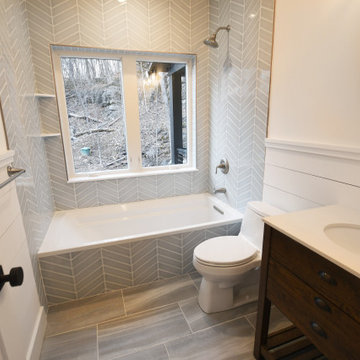 Guest bathroom with herringbone tile tub and picture window.