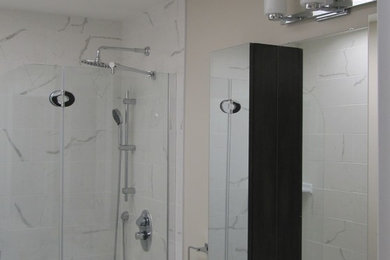 Foto de cuarto de baño minimalista de tamaño medio con lavabo integrado, armarios con paneles lisos, puertas de armario de madera en tonos medios, encimera de laminado, ducha esquinera y baldosas y/o azulejos blancos