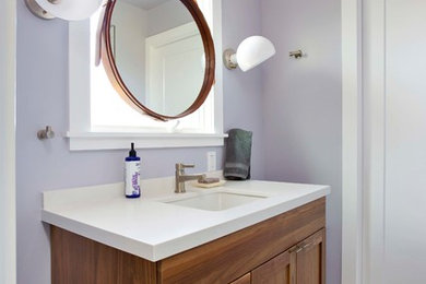 Corner shower - small transitional white tile and ceramic tile ceramic tile and gray floor corner shower idea in San Francisco with shaker cabinets, dark wood cabinets, a one-piece toilet, purple walls, an undermount sink, quartz countertops, a hinged shower door and gray countertops