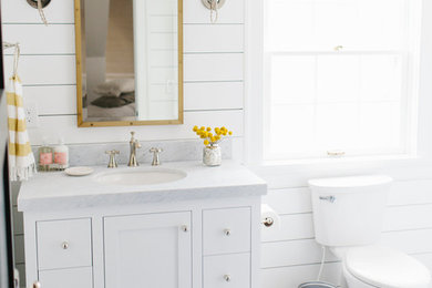 Inspiration for a mid-sized coastal 3/4 porcelain tile bathroom remodel in Toronto with shaker cabinets, white cabinets, a two-piece toilet, white walls, an undermount sink and marble countertops