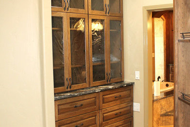 Exempel på ett medelhavsstil en-suite badrum, med luckor med upphöjd panel, skåp i mellenmörkt trä, klinkergolv i keramik, keramikplattor och granitbänkskiva