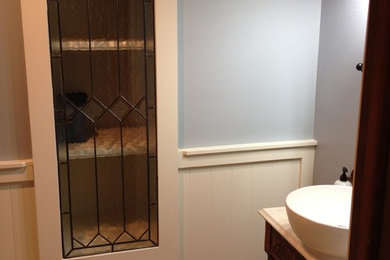 Ejemplo de cuarto de baño contemporáneo pequeño con armarios tipo mueble, puertas de armario de madera en tonos medios, sanitario de dos piezas, paredes azules, lavabo sobreencimera, encimera de cuarzo compacto y encimeras blancas