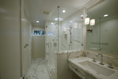 Alcove shower - mid-sized transitional marble floor alcove shower idea in Sacramento with an undermount sink, furniture-like cabinets, white cabinets, marble countertops, a one-piece toilet and beige walls
