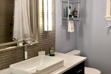 Exempel på ett mellanstort modernt vit vitt badrum, med skåp i shakerstil, svarta skåp, ett badkar i en alkov, en dusch/badkar-kombination, en toalettstol med separat cisternkåpa, grå kakel, keramikplattor, blå väggar, klinkergolv i porslin, ett fristående handfat, bänkskiva i kvarts, grått golv och dusch med duschdraperi