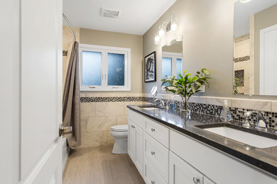 Mid-sized trendy 3/4 beige tile and ceramic tile ceramic tile and beige floor bathroom photo in Chicago with shaker cabinets, white cabinets, a two-piece toilet, beige walls, an undermount sink, quartzite countertops and black countertops