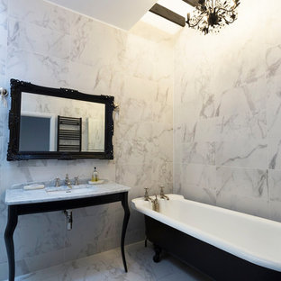 Photo of a medium sized bohemian ensuite bathroom in Surrey with a freestanding bath, marble tiles, ceramic flooring, marble worktops, white floors, white walls, grey worktops, white tiles and a submerged sink.