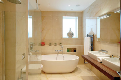 Foto de cuarto de baño contemporáneo con bañera exenta, ducha abierta, baldosas y/o azulejos de piedra, suelo de mármol y ducha abierta