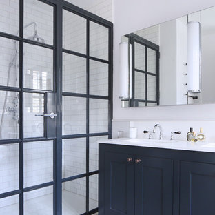 Exempel på ett mellanstort minimalistiskt badrum med dusch, med skåp i shakerstil, blå skåp, vita väggar, ett undermonterad handfat, linoleumgolv, en öppen dusch, vit kakel, tunnelbanekakel och dusch med gångjärnsdörr