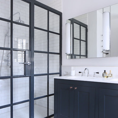 Doorless shower - mid-sized scandinavian 3/4 white tile and subway tile linoleum floor doorless shower idea in London with shaker cabinets, blue cabinets, white walls, an undermount sink and a hinged shower door