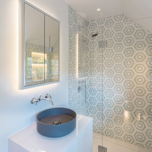 This is an example of a contemporary bathroom in London with flat-panel cabinets, white cabinets, an alcove shower, grey tiles, white walls, a vessel sink, grey floors, a hinged door, white worktops, a single sink, a floating vanity unit and a vaulted ceiling.