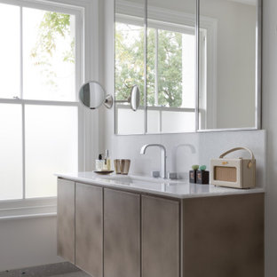 Modelo de cuarto de baño principal, ecléctico, grande, sin sin inodoro, con armarios con paneles lisos, puertas de armario beige, sanitario de pared, baldosas y/o azulejos blancos, baldosas y/o azulejos en mosaico, paredes beige, suelo de baldosas de cerámica, lavabo integrado, encimera de cuarcita, suelo beige, ducha abierta y encimeras blancas