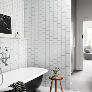 Contemporary master bathroom in Melbourne with flat-panel cabinets, black cabinets, a claw-foot tub, a corner shower, a wall-mount toilet, white tile, ceramic tile, white walls, marble floors, a console sink, engineered quartz benchtops, grey floor, a hinged shower door and white benchtops.