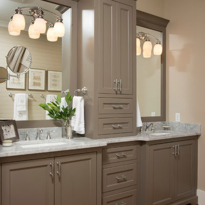 Mid-sized country master medium tone wood floor bathroom photo in Charleston with an undermount sink, recessed-panel cabinets, gray walls, marble countertops and brown cabinets