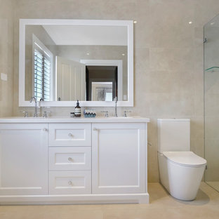 Photo of a large traditional 3/4 bathroom in Sydney with shaker cabinets, white cabinets, a curbless shower, a two-piece toilet, beige tile, an undermount sink, beige floor and white benchtops.