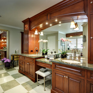 Inspiration for a large timeless master multicolored tile and stone tile limestone floor and multicolored floor bathroom remodel in Portland with an undermount sink, raised-panel cabinets, dark wood cabinets, a one-piece toilet, green walls, granite countertops, a hinged shower door and green countertops